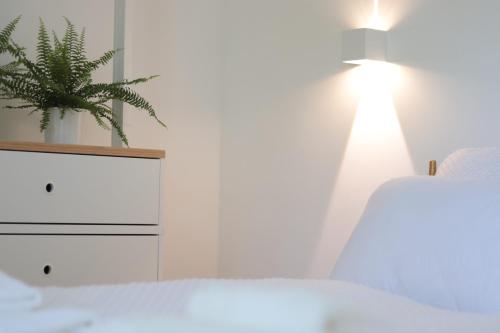 a bedroom with a bed and a plant on the wall at Lechner4 Residence in Szeged