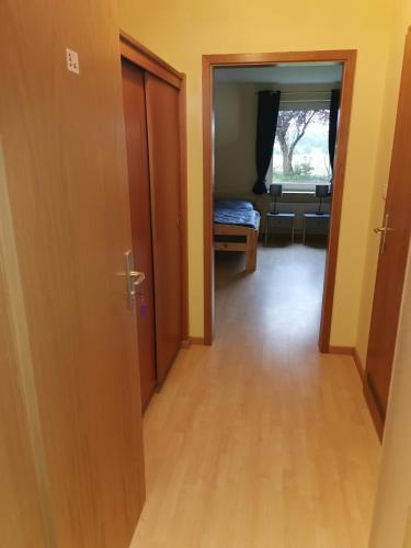 a hallway with a door and a room with a bed at Hornbrooker Hostel in Dersau