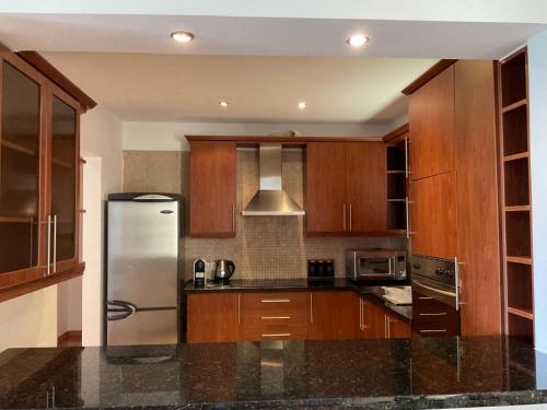 a kitchen with wooden cabinets and a stainless steel refrigerator at StayCity Flat!!! in Nicosia