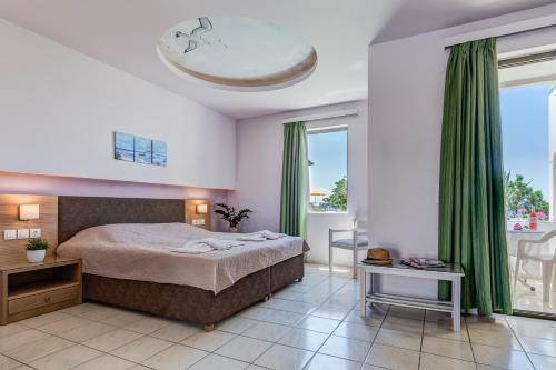 una camera da letto con un grande letto con tende verdi di Alkionis Beach Hotel Apartments a Sfakaki
