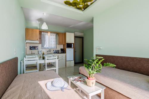 a living room with a couch and a kitchen at Alkionis Beach Hotel Apartments in Sfakaki