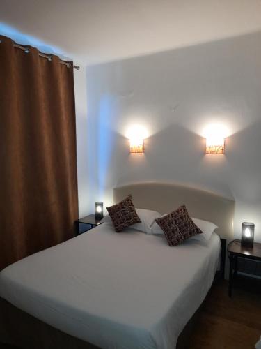 1 dormitorio con 1 cama blanca grande y 2 lámparas en Au Moulin Du Pont en Samognat