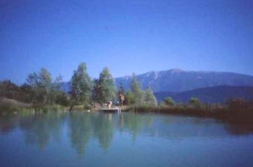 a large lake with a house in the middle of it at Charmant appartement Eygaliers 60m² avec vue lac et montagne in Eygaliers