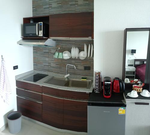 a kitchen with a sink and a microwave at Beachfront Pool Villa and Apartment in Ko Chang