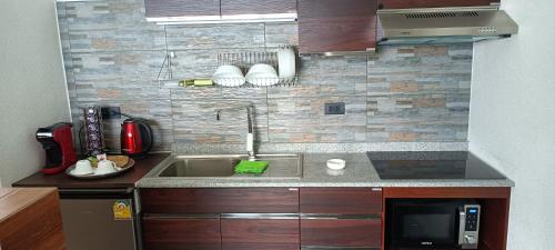 a small kitchen with a sink and a microwave at Beachfront Pool Villa and Apartment in Ko Chang