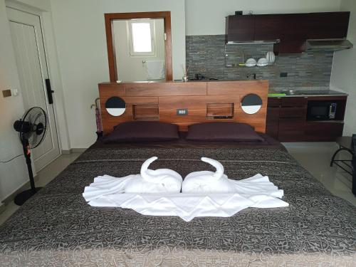 a bedroom with a bed with two white towels on it at Beachfront Pool Villa and Apartment in Ko Chang