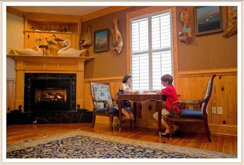 a woman and boy sitting at a table in a living room at Shutters on the Banks in Kill Devil Hills