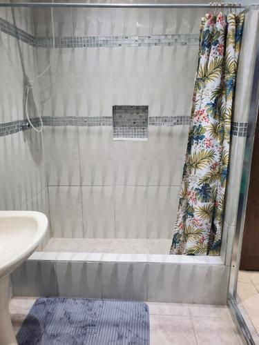 a shower with a shower curtain in a bathroom at Preferred Place in Trincity 