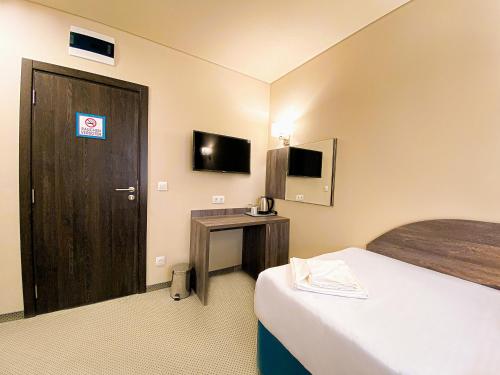 a hotel room with a bed and a door and a desk at Terminal Park in Bischofsheim