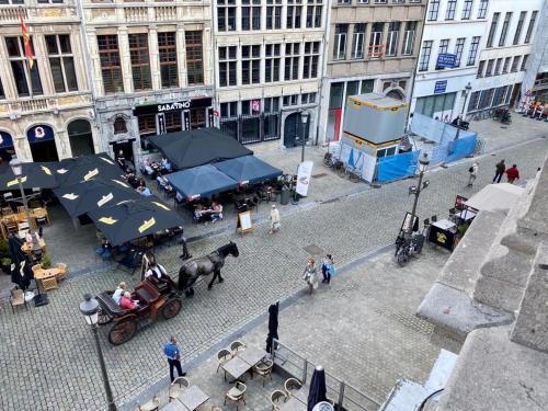a city street with a horse drawn carriage and people at Antwerp City Hostel in Antwerp