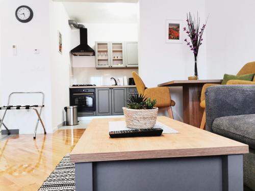 a living room with a table and a kitchen at Apartman Angel in Osijek