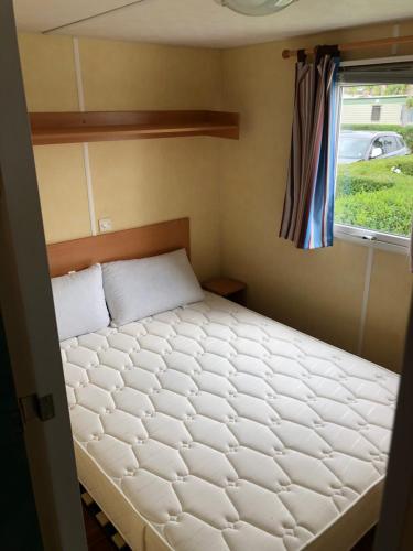 a bed in a small room with a window at Mobil-home 5 personnes proche de la plage in Berck-sur-Mer