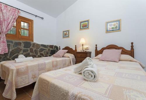 a bedroom with two beds and a couch at El Puntal de Nieves in Nerja