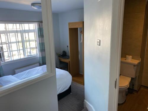 a small room with a bed and a window at Queen Street Tap in Deal