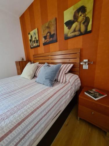 een slaapkamer met een bed met een houten hoofdeinde bij Dos Torres Edificio de los Arcos 5 - Plaza de Parking Incluida in Zaragoza