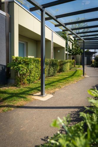 a walkway in front of a building at Hotel Libera Caen Colombelles in Caen