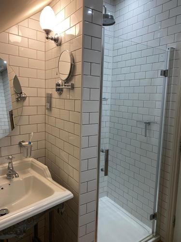 a bathroom with a sink and a shower at Duke of Monmouth penthouse luxury apartment, Lyme Regis, 3 bedroom, Hot tub, Garden, dog friendly in Lyme Regis