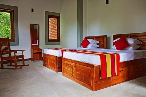 a bedroom with two large wooden beds and a chair at The Hideaway in Kurunegala