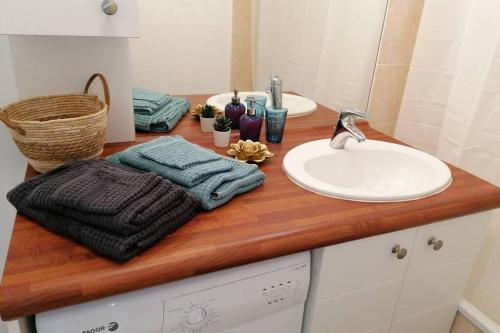 eine Badezimmertheke mit einem Waschbecken und einem Spiegel in der Unterkunft T2 entier - Hyper centre - Cosy home in Grenade-sur-Garonne