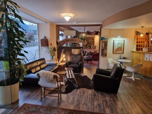 a living room with leather furniture and a fireplace at Hotel Le Beau Site in Saint-Pierre-de-Chartreuse
