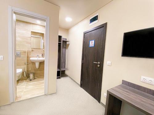 a bathroom with a toilet and a television on a wall at Terminal Park in Bischofsheim