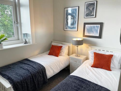 sypialnia z 2 łóżkami i oknem w obiekcie The Portside Apartment w mieście Greenock