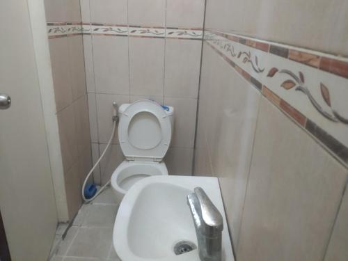 a small bathroom with a toilet and a sink at Modern Indekos Cilegon Syariah RedPartner in Grogol