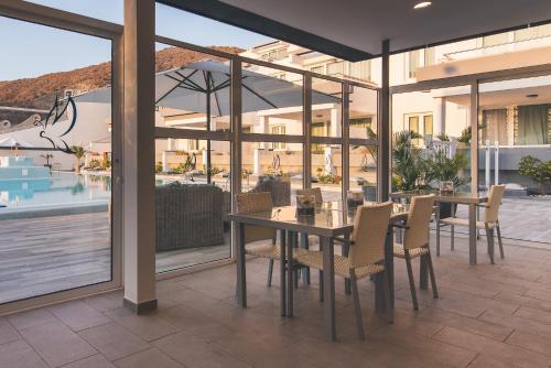a patio with a table and chairs and a pool at Mariposa Del Sol in Patalavaca