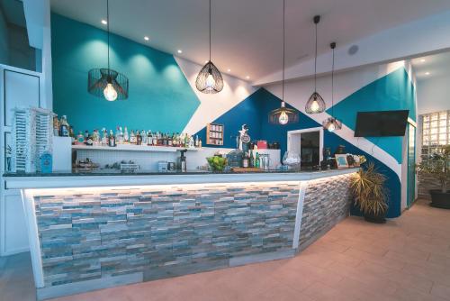 a bar in a restaurant with a blue wall at Mariposa Del Sol in Patalavaca