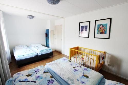 sypialnia z 2 łóżkami i łóżeczkiem dziecięcym w obiekcie Valhalla w mieście Egmond-Binnen