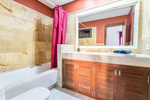 een badkamer met een bad, een wastafel en een spiegel bij Villa Tania - Villa independiente con piscina privada in Playa Blanca