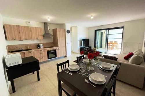 Il comprend un salon avec une table à manger et une cuisine. dans l'établissement Apparté - Appartement proche Genève et Palexpo, à Ferney-Voltaire