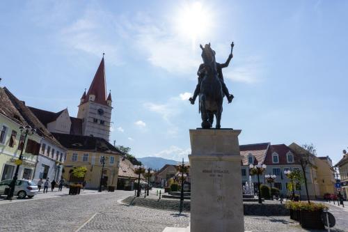 a statue of a man on a horse on a street at Hotel Epic Centrum in Cisnădie
