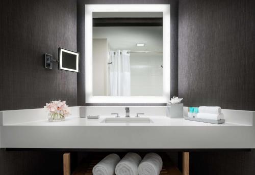 a bathroom with a sink and a mirror and towels at Hyatt Regency Bethesda near Washington D.C. in Bethesda