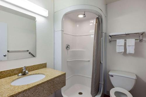 a bathroom with a sink and a toilet and a shower at Travelodge by Wyndham Miles City in Miles City