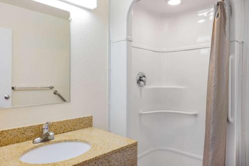 a bathroom with a sink and a shower at Travelodge by Wyndham Miles City in Miles City