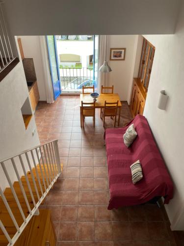 ein Wohnzimmer mit einem roten Sofa und einem Tisch in der Unterkunft Apartament Riera in Cadaqués