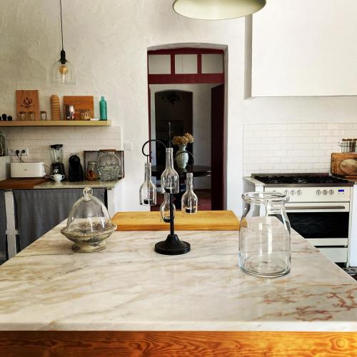 a kitchen counter with two glass vases on it at Monte Capitão Country house in Salvada