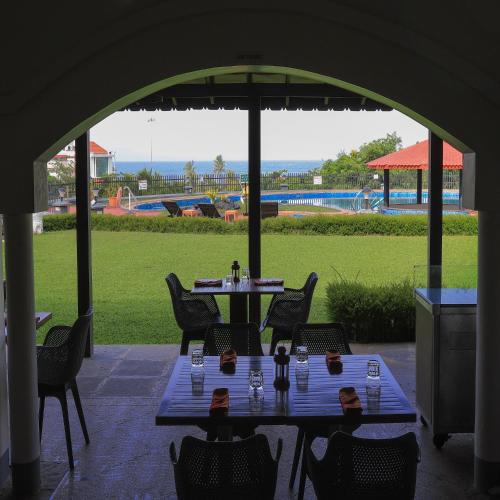 two people sitting at tables under an umbrella on a patio at Gateway Varkala in Varkala