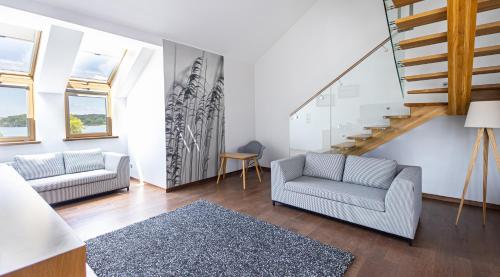 a living room with two chairs and a staircase at Hotel Marina Club in Olsztyn