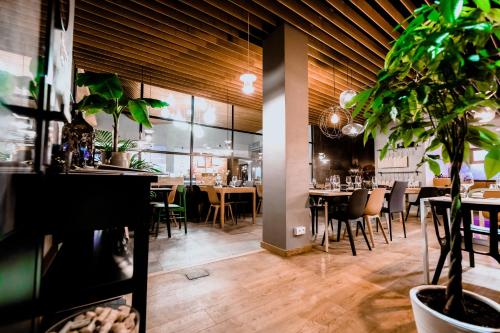 a dining room with tables and chairs and plants at Hotel Marina Club in Olsztyn