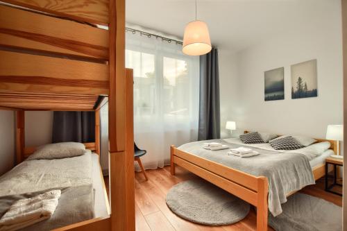 a bedroom with a bed and a bunk bed at Apartamenty MIWA in Szczyrk