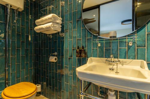 a bathroom with a sink and a toilet and a mirror at Riva Boutique Hotel in Helensburgh