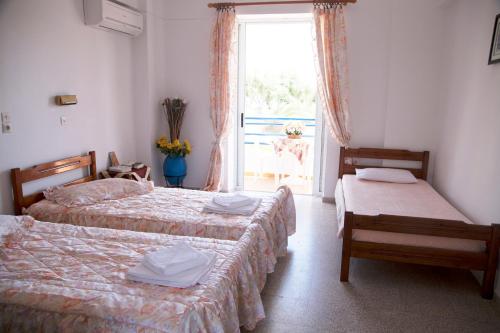 ein Hotelzimmer mit 2 Betten und einem Fenster in der Unterkunft Maritsa in Kefalos