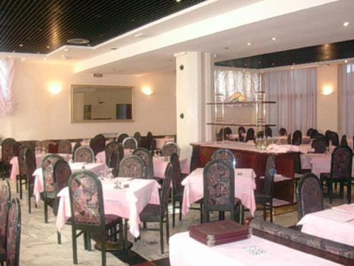 un comedor con mesas y sillas con mantel rosa en Hotel Excelsior, en Latina