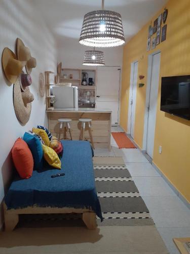 a living room with a blue bed and a kitchen at Formosinha in Baía Formosa