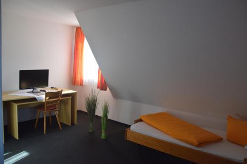 a room with a desk with a computer and a bed at Hotel-Gasthof Rössle in Ulm