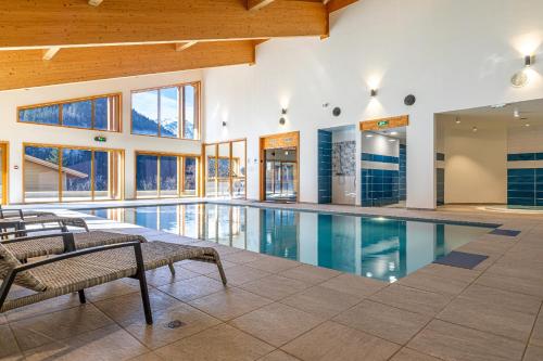 - une piscine dans un bâtiment doté de fenêtres dans l'établissement FranceComfort - AlpChalets Portes du Soleil, à Abondance