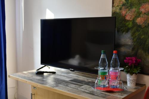 a television with three bottles on a table at Hotel Münchner Hof in Frankfurt