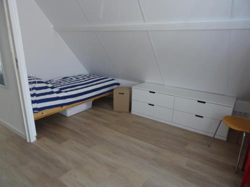 a small room with a bed and a dresser at Kustverhuur, Breskens, Nijverheidstraat 11 in Breskens